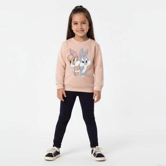 Young girl wearing a pink sweatshirt with cartoon characters on a white background